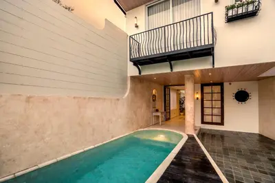 an indoor pool in a house with a staircase at Villa Umabell Villa Seminyak in Seminyak