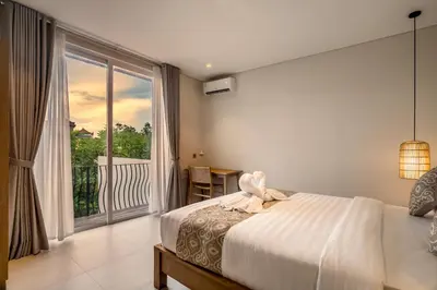 a bedroom with a bed and a large window at Villa Umabell Villa Seminyak in Seminyak