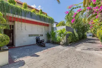 a motorcycle parked outside of a building with pink flowers at Luxury 4 Bedroom Villa Seminiak in Seminyak