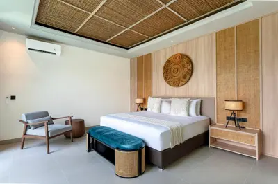 a hotel room with a bed and a chair at Deneva Villa by Betterplace in Canggu