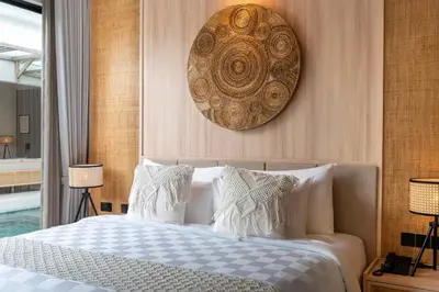 a bedroom with a large bed with white pillows at Deneva Villa by Betterplace in Canggu