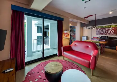 a living room with a red couch and a table at Viva Dash Hotel Seminyak in Seminyak