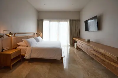 a bedroom with a bed and a television on the wall at Fale Seminyak - Brand New Modern Luxury 5BR Villa in Seminyak with Private Pool, Gym & Massage Room in Seminyak
