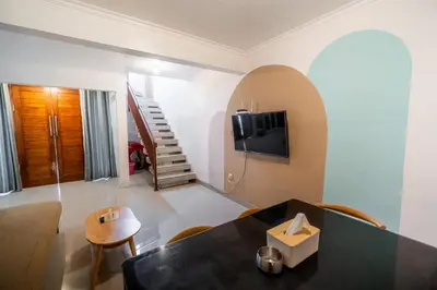a living room with a table and a tv at House Jimbaran Kuta 3 bedroom 8 pax SukaBali 6 in Jimbaran