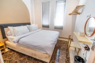 a bedroom with a bed with white sheets and a mirror at House Jimbaran Kuta 3 bedroom 8 pax SukaBali 6 in Jimbaran