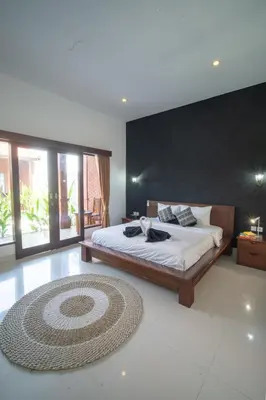 a bedroom with a large bed and a large rug at Villa Moza in Canggu