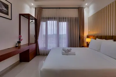 a bedroom with a large white bed and a window at Villa Taman Seminyak 44 near Double Six Beach in Seminyak