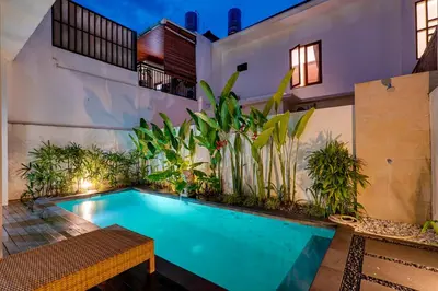 a swimming pool in front of a building with plants at Villa Taman Seminyak 44 near Double Six Beach in Seminyak