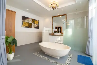 a bathroom with a large white tub and a shower at Villa Bali Road House Seminyak in Seminyak