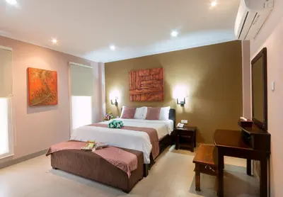 a hotel room with a bed and a television at Peninsula Bay Resort in Nusa Dua