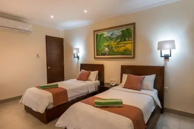 a hotel room with two beds and a painting on the wall at Peninsula Bay Resort in Nusa Dua