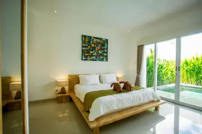 a bedroom with a bed and a large window at Bluna Villa seminyak in Seminyak