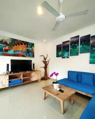 a living room with a blue couch and a tv at Bluna Villa seminyak in Seminyak