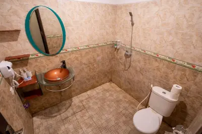 a bathroom with a shower with a toilet and a mirror at The Mupu Seminyak in Seminyak