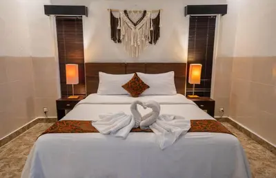 a bedroom with a bed with two swans towels at The Mupu Villa Seminyak in Seminyak