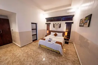 a bedroom with a large bed and a large window at The Mupu Villa Seminyak in Seminyak