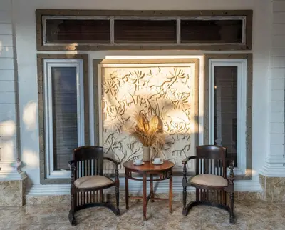 a group of chairs and a table in front of a wall at The Mupu Villa Seminyak in Seminyak