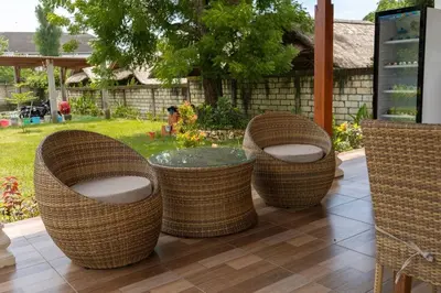 four wicker chairs and a table on a patio at UCU VILLAGE at ULUWATU JIMBARAN in Jimbaran