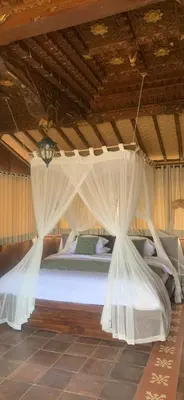 a bedroom with a bed with white drapes at Wakajima House kuta Utara in Kerobokan