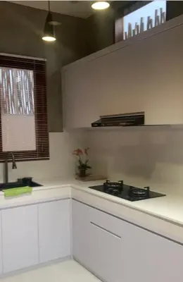 a kitchen with white cabinets and a stove and a window at Wakajima House kuta Utara in Kerobokan