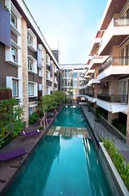 a swimming pool in the middle of a building at Quest San Denpasar by ASTON in Denpasar
