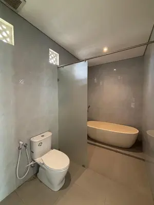 a bathroom with a toilet and a bath tub at Villa Taoro Jimbaran in Jimbaran
