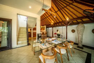 a dining room with a table and some chairs at Villa Panda Seminyak next to KU DE TA Beach Club in Seminyak