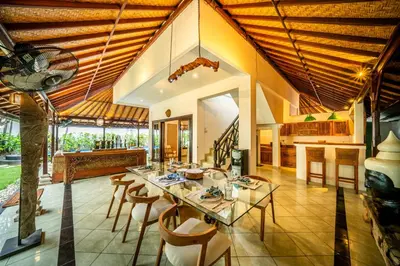 a dining room with a glass table and chairs at Villa Panda Seminyak next to KU DE TA Beach Club in Seminyak
