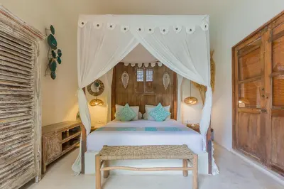 a bedroom with a white bed with a canopy at Luxury 3BR Villa Daenerys Pool Ricefield Family-Friendly Near Canggu in Kerobokan