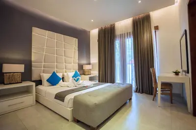 a bedroom with a large bed with blue pillows at Villa Orange 2BR Seminyak by Exotic Bali Properties in Badung
