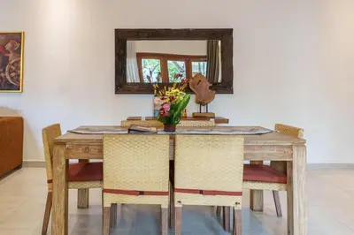 a dining room table with chairs and a mirror at Villa Orange 2BR Seminyak by Exotic Bali Properties in Badung
