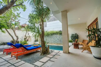a patio with a blue and red couch and a tree at Villa Orange 2BR Seminyak by Exotic Bali Properties in Badung