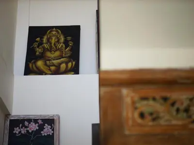 a picture of a buddha on a wall next to a door at Ken Ken Guest House in Seminyak