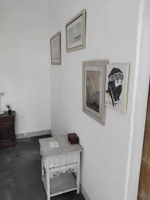 a room with a table and pictures on the wall at Jimbaran room 01 in Jimbaran