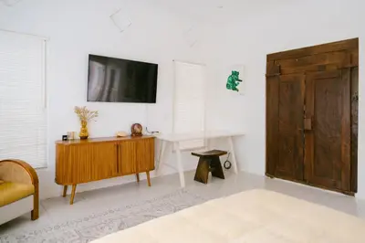 a living room with a tv and a wooden cabinet at Villa Kubu Lebak 3 in Seminyak