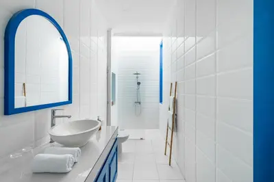 a white bathroom with a sink and a mirror at Casa Posa Seminyak in Seminyak