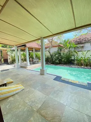 an empty patio with a large umbrella and a pool at Classic Villa with Private Pool in Kuta