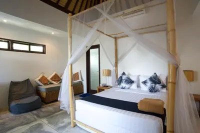 a bedroom with a canopy bed and a couch at Your Tropical Oasis Mason Villas Seminyak in Seminyak