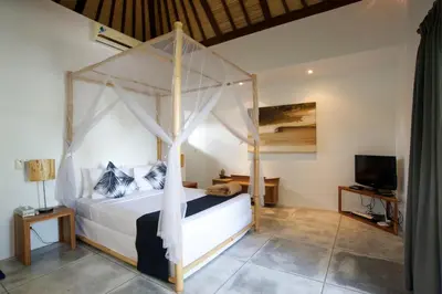 a bedroom with a canopy bed and a television at Your Tropical Oasis Mason Villas Seminyak in Seminyak