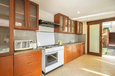 a kitchen with a stove and a microwave at 4 Bedroom Private Villa Umalas 2 in Seminyak