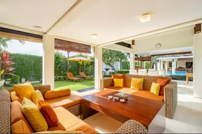 a living room with yellow pillows and a wooden table at 4 Bedroom Private Villa Umalas 2 in Seminyak
