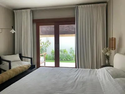 a bedroom with a bed and a large window at Top Villa Ilo, best area near canggu 250 m2 on 750 m2 land in Kerobokan