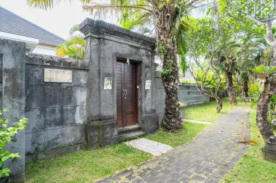 an old building with a red door on a street at Melati Villa by iBali Management in Legian