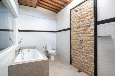 a bathroom with a toilet and a bath tub at Melati Villa by iBali Management in Legian