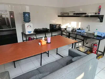 a kitchen with a table and a couch in it at HK Villa Family in Seminyak