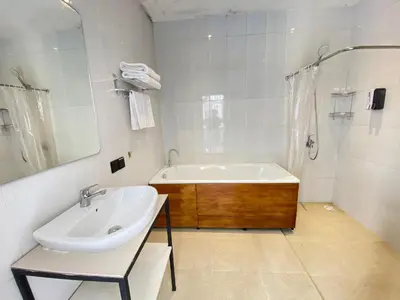 a white bathroom with a tub and a sink at HK Villa Family in Seminyak