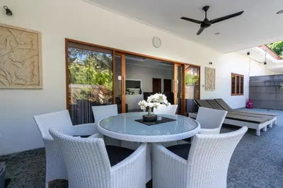 a dining room with a glass table and chairs at 3 Bedroom Villa Mawar walk to Beach Legian in Legian