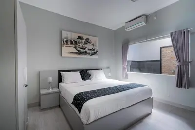 a white bedroom with a bed and a window at 3 Bedroom Villa Mawar walk to Beach Legian in Legian