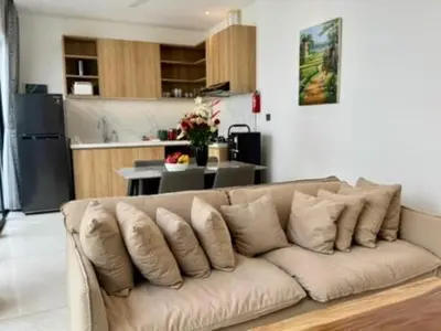 a couch in a living room with a kitchen at Villa Kumala Sari in Seminyak