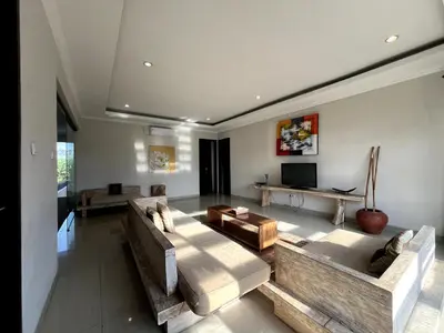 a large living room with a couch and a tv at White Lotus Villa by Miel Property in Seminyak
